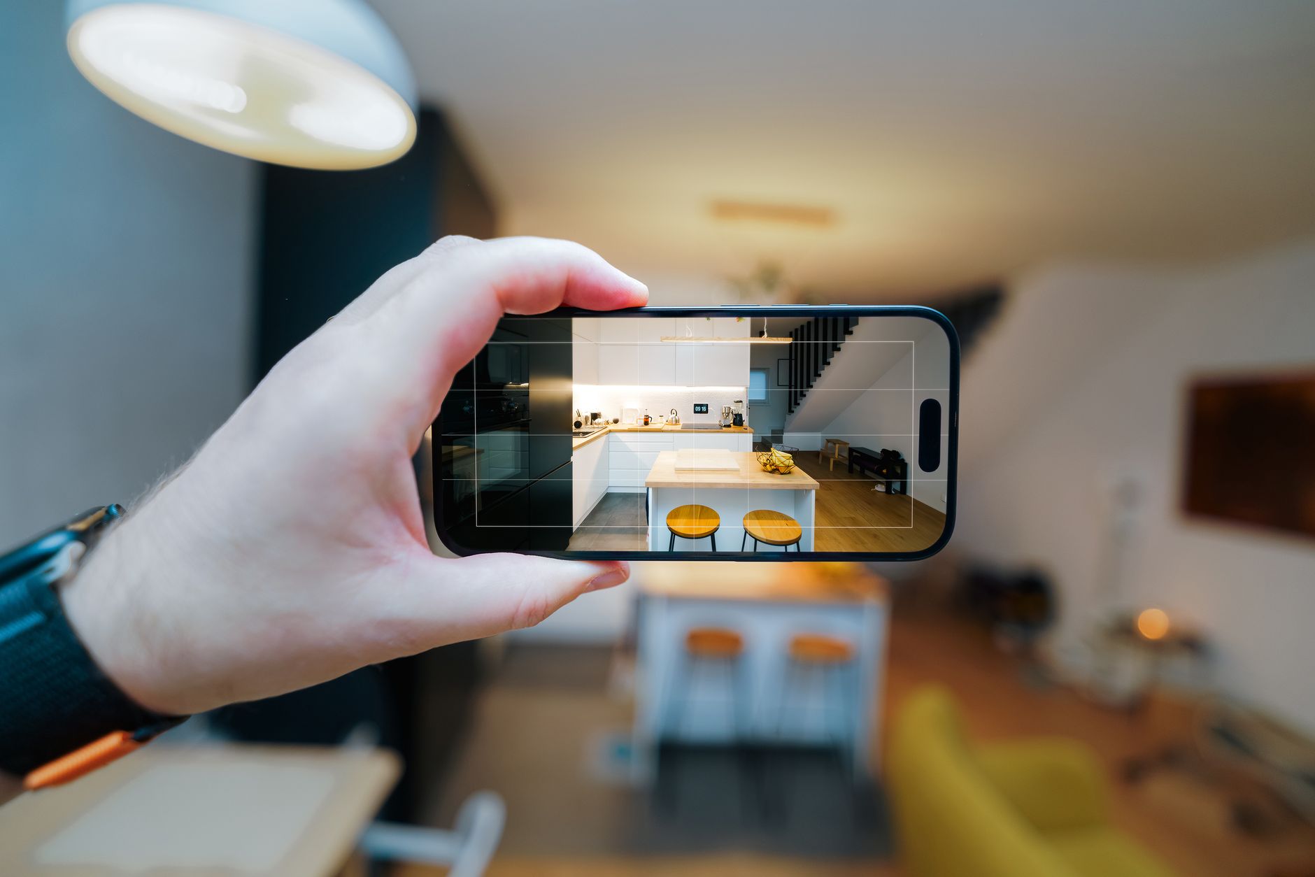 A homeowner using a smartphone to photograph their kitchen for a renovation estimate