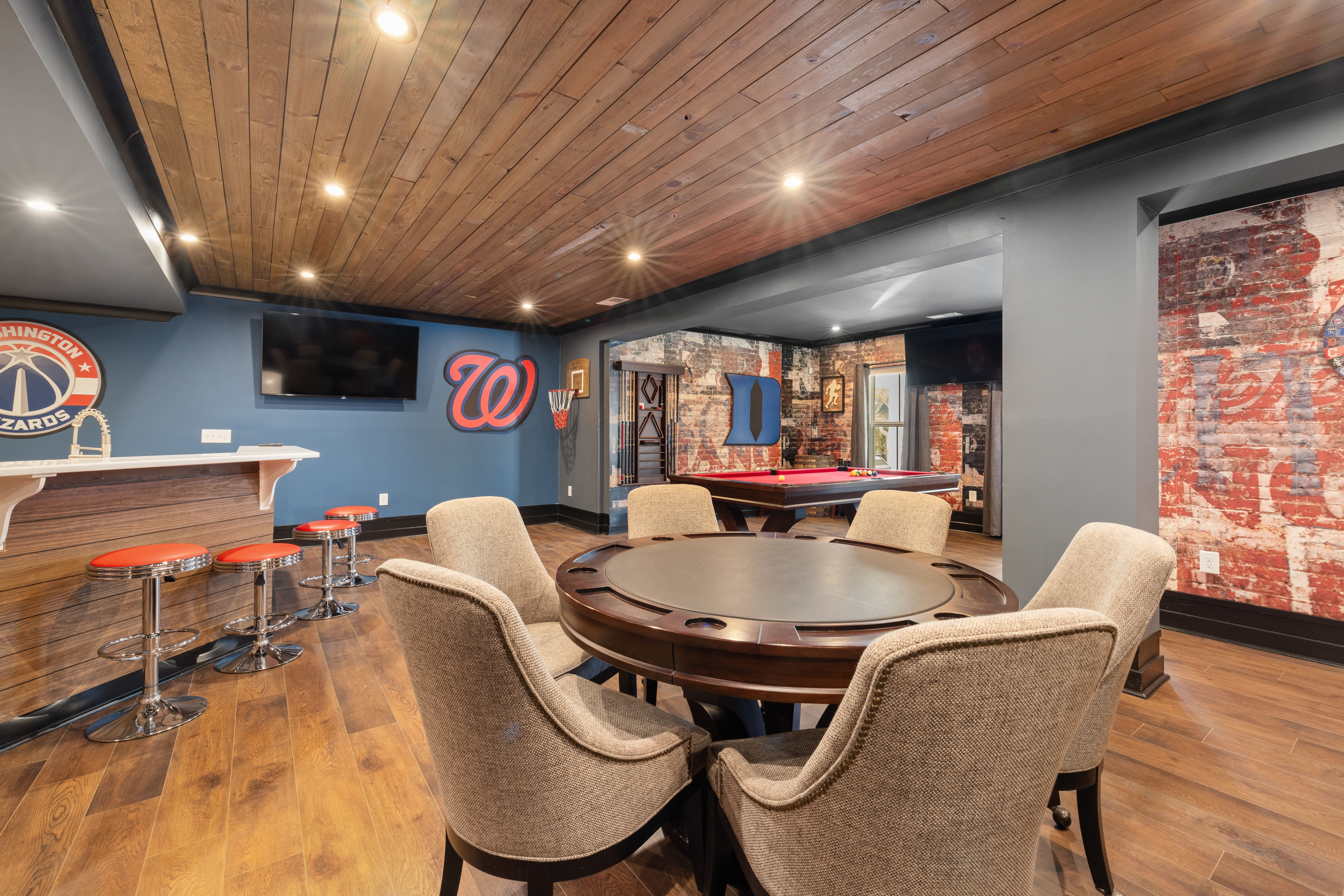 Finished basement rec room with a built-in bar, pool table, and warm ambient lighting